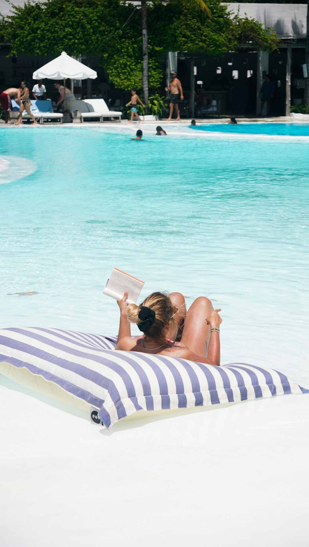 senior man reading book by pool