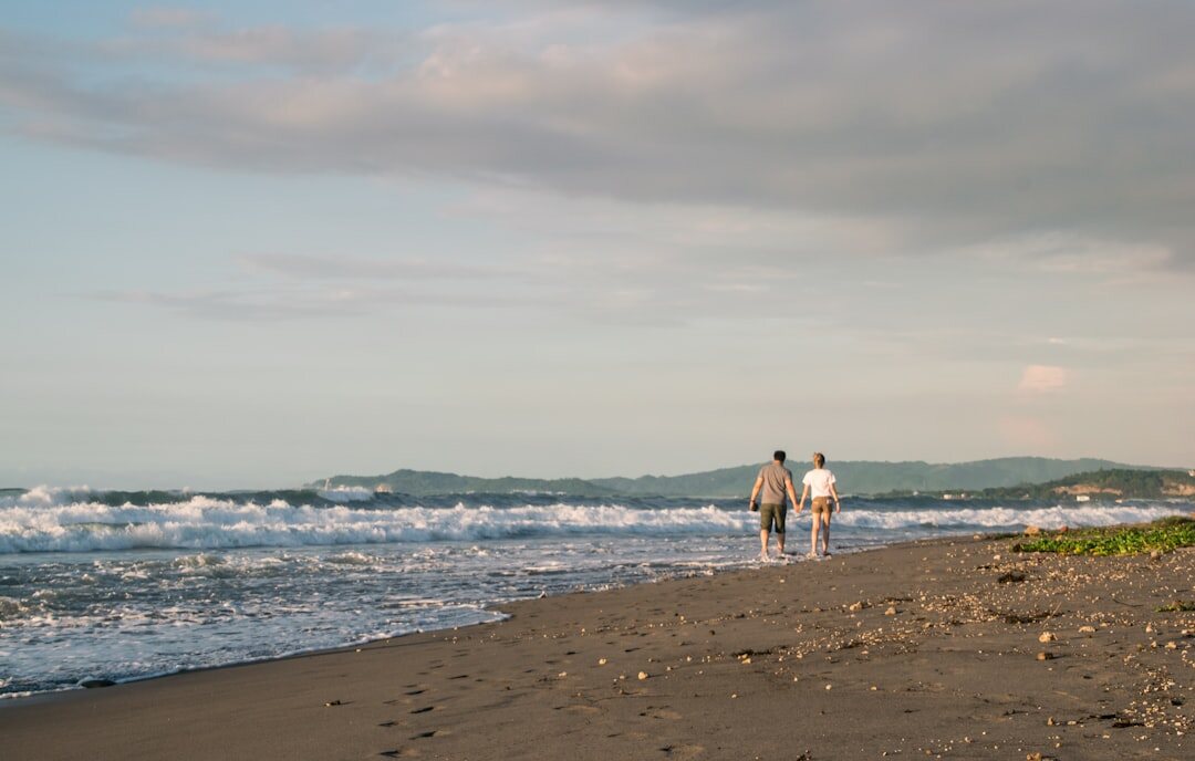 retired couple walking on beach