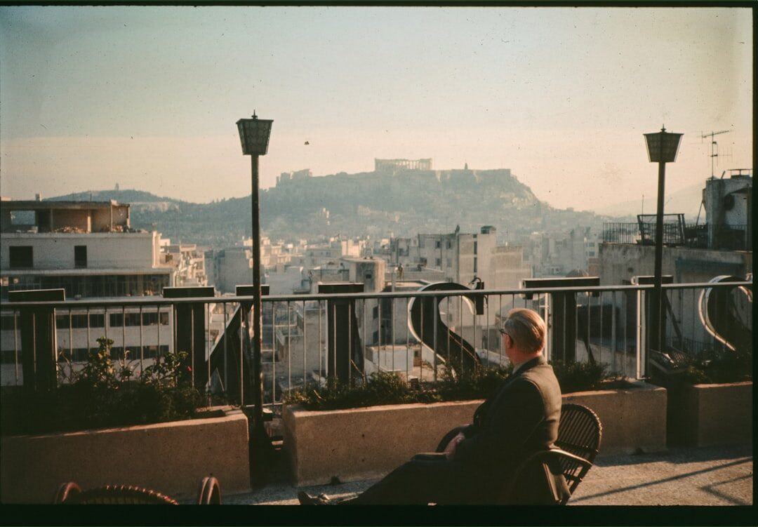 senior man reading book on balcony