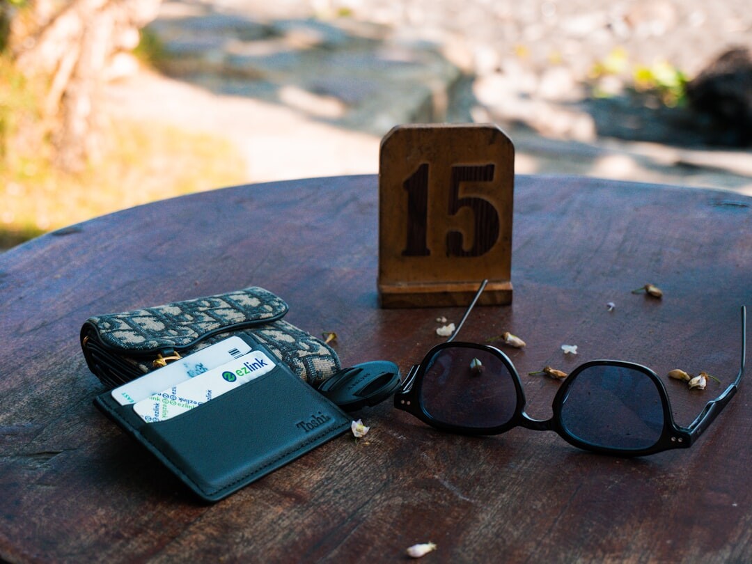 Travel guidebook, passport and sunglasses on a wooden table